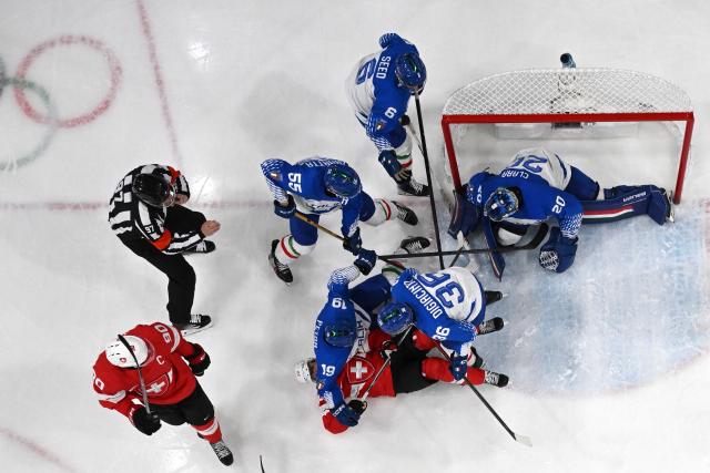 Switzerland's #22 Nino Niederreiter and Italy's #19 Alex Petan fall during the men's qualification play-off ice hockey match between Switzerland and Italy during the Milano Cortina 2026 Winter Olympic Games at the Milano Rho Ice Hockey Arena in Milan, on February 17, 2026. (Photo by Piero CRUCIATTI / AFP)