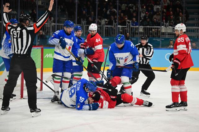Switzerland's #22 Nino Niederreiter and Italy's #19 Alex Petan fall during the men's qualification play-off ice hockey match between Switzerland and Italy during the Milano Cortina 2026 Winter Olympic Games at the Milano Rho Ice Hockey Arena in Milan, on February 17, 2026. (Photo by Piero CRUCIATTI / AFP)