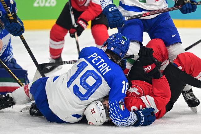 Switzerland's #22 Nino Niederreiter and Italy's #19 Alex Petan fall during the men's qualification play-off ice hockey match between Switzerland and Italy during the Milano Cortina 2026 Winter Olympic Games at the Milano Rho Ice Hockey Arena in Milan, on February 17, 2026. (Photo by Piero CRUCIATTI / AFP)