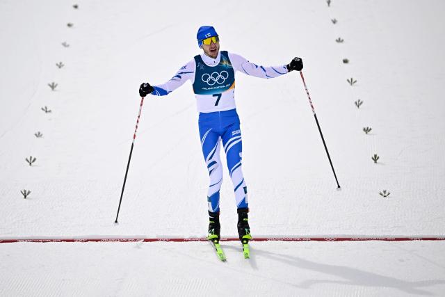 Finland's Ilkka Herola celebrates after crossing the finish to win bronze in the cross-country event of the nordic combined individual Gundersen large hill/10km at Tesero Cross Country Stadium at Lago di Tesero (Val di Fiemme) during the Milano Cortina 2026 Winter Olympic Games on February 17, 2026. (Photo by Tobias SCHWARZ / AFP)