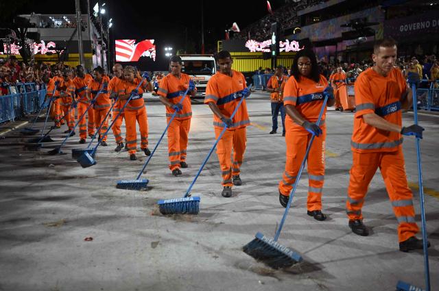 Cleaning staff sweep the Marques de Sapucai Sambadrome before the presentation of Unidos da Tijuca samba school during the second night of the Rio Carnival, in Rio de Janeiro, Brazil, early on February 17, 2026. (Photo by Mauro PIMENTEL / AFP)