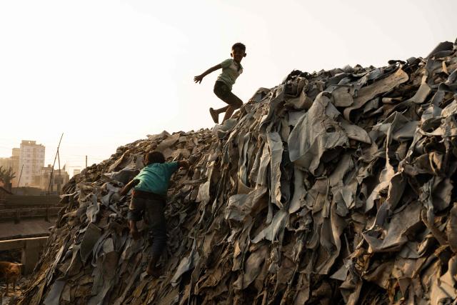Children play at a tannery in Dhaka on February 17, 2026. (Photo by MOHD RASFAN / AFP)