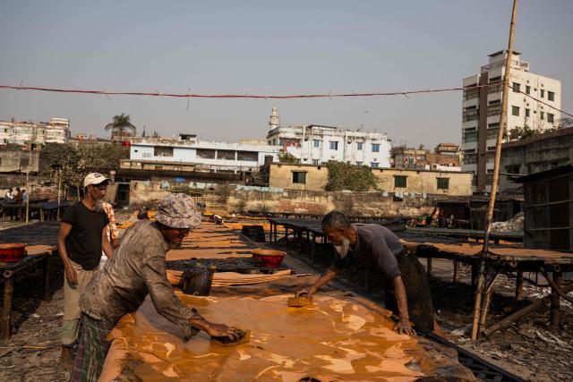 Bangladeshi labourers paint leather at a tannery in Dhaka on February 17, 2026. (Photo by MOHD RASFAN / AFP)