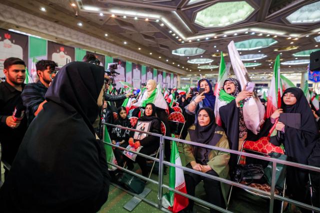 Iran's government spokesperson Fatemeh Mohajerani (L) speaks to relatives of victims during a memorial ceremony marking the 40th day of mourning for victims of "terrorism" killed in previous anti-government protests in Iran, at the Tehran Musalla on February 17, 2026. (Photo by ATTA KENARE / AFP)