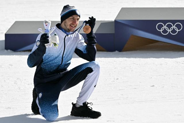 Bronze medallist Finland's Ilkka Herola poses with his medal by the podium following the nordic combined individual Gundersen large hill/10km event at Tesero Cross Country Stadium at Lago di Tesero (Val di Fiemme) during the Milano Cortina 2026 Winter Olympic Games on February 17, 2026. (Photo by Javier SORIANO / AFP)