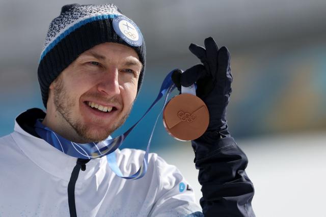 Bronze medallist Finland's Ilkka Herola celebrates on the podium following the nordic combined individual Gundersen large hill/10km event at Tesero Cross Country Stadium at Lago di Tesero (Val di Fiemme) during the Milano Cortina 2026 Winter Olympic Games on February 17, 2026. (Photo by Anne-Christine POUJOULAT / AFP)