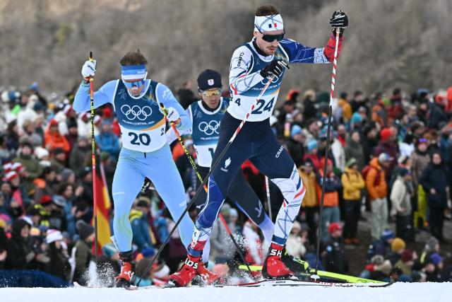Slovenia's Vid Vrhovnik (L) and France's Mael Tyrode (R) compete in the cross-country event of the nordic combined individual Gundersen large hill/10km at Tesero Cross Country Stadium at Lago di Tesero (Val di Fiemme) during the Milano Cortina 2026 Winter Olympic Games on February 17, 2026. (Photo by Javier SORIANO / AFP)