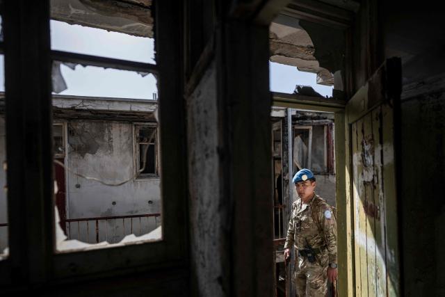 TOPSHOT - Lance Corporal Robertsing Neyong Limbu of the United Nations Peacekeeping Force in Cyprus (UNFICYP), from the British Army’s 1st Battalion Coldstream Guards, No. 2 Company, patrols along the buffer zone separating the internationally recognized Republic of Cyprus and the breakaway Turkish Republic of Northern Cyprus — recognized only by Ankara — in the divided capital Nicosia on February 17, 2026. Cyprus has been divided since 1974, when a Turkish invasion followed a coup in Nicosia backed by Greece’s then military junta. The Turkish Republic of Northern Cyprus, declared in 1983, is recognized only by Ankara, while the internationally recognized Republic of Cyprus — a member of the European Union — controls the island’s majority Greek Cypriot south. There are currently nine crossings along the UN-patrolled Green Line separating the two sides, and calls have grown for additional crossings along the 180-kilometre (110-mile) buffer zone to ease access for people in remote areas. Thousands cross daily for work, education or medical care using the crossings operational since 2003, while reunification efforts brokered by the United Nations have remained frozen since talks collapsed in 2017. (Photo by Jewel SAMAD / AFP)