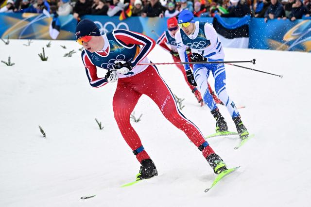 Norway's Jens Luraas Oftebro (L) and Finland's Ilkka Herola compete in the cross-country event of the nordic combined individual Gundersen large hill/10km at Tesero Cross Country Stadium at Lago di Tesero (Val di Fiemme) during the Milano Cortina 2026 Winter Olympic Games on February 17, 2026. (Photo by Tobias SCHWARZ / AFP)