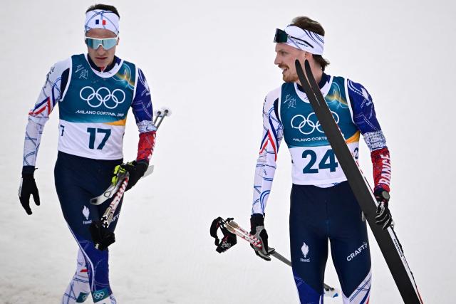 France's Laurent Muhlethaler (L) and France's Mael Tyrode react after competing in the cross-country event of the nordic combined individual Gundersen large hill/10km at Tesero Cross Country Stadium at Lago di Tesero (Val di Fiemme) during the Milano Cortina 2026 Winter Olympic Games on February 17, 2026. (Photo by Tobias SCHWARZ / AFP)