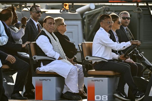 India's Defence Minister Rajnath Singh (centre L) with his French counterpart Catherine Vautrin (centre R) takes a tour of the production facility for Airbus H125 helicopters, after its inauguration at Vemagal in Kolar district on February 17, 2026. India's Tata Group and European aviation giant Airbus opened a helicopter final assembly line on February 17, a significant step in New Delhi's flagship "Make in India" drive. The virtual opening was made by Indian Prime Minister Narendra Modi and visiting French President Emmanuel Macron. (Photo by Idrees MOHAMMED / AFP)