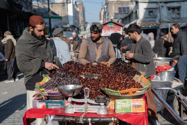 Afghans purchase dates at a market in Kabul on February 17, 2026 ahead of the Islamic holy fasting month of Ramadan. (Photo by Wakil KOHSAR / AFP)