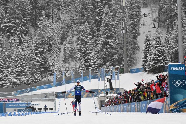 France's Eric Perrot celebrates as he crosses the finish line to win the men's biathlon 4 x 7,5km relay event during the Milano Cortina 2026 Winter Olympic Games at the Anterselva Biathlon Arena (Sudtirol Arena) in Anterselva (Val Pusteria) on February 17, 2026. (Photo by Franck FIFE / AFP)