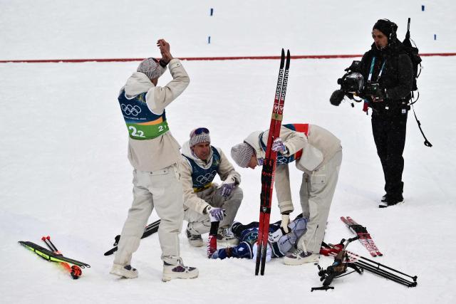 France's Eric Perrot (C) is greeted by France's Quentin Fillon Maillet, France's Emilien Jacquelin and France's Fabien Claude as he celebrates after crossing the finish line to win the men's biathlon 4 x 7,5km relay event during the Milano Cortina 2026 Winter Olympic Games at the Anterselva Biathlon Arena (Sudtirol Arena) in Anterselva (Val Pusteria) on February 17, 2026. (Photo by Marco BERTORELLO / AFP)