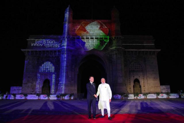 India's Prime Minister Narendra Modi (R) and France's President Emmanuel Macron shake hands during the India-France Year of Innovation and Cultural Commemoration event at the Gateway of India in Mumbai on February 17, 2026. (Photo by Ludovic MARIN / AFP)