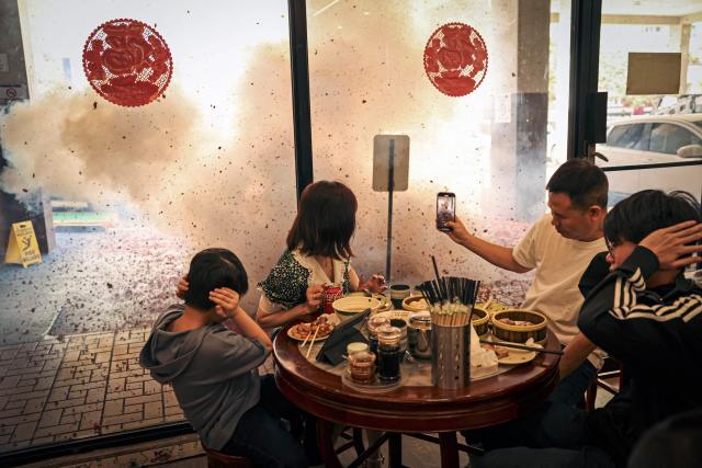 Chinese residents in Panama react to firecrackers outside a restaurant during Lunar New Year celebrations marking the beginning of the Year of the Horse, in Panama City on February 17, 2026. (Photo by MARTIN BERNETTI / AFP)