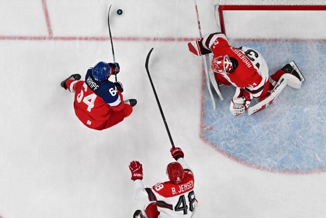Czech Republic's #64 David Kampf (L) and Denmark's #31 Frederik Andersen (R) vie for the puck during the men's qualification play-off ice hockey match between Czech Republic and Denmark at the Milano Santagiulia Ice Hockey Arena during the Milano Cortina 2026 Winter Olympic Games in Milan, on February 17, 2026. (Photo by Alexander NEMENOV / AFP)