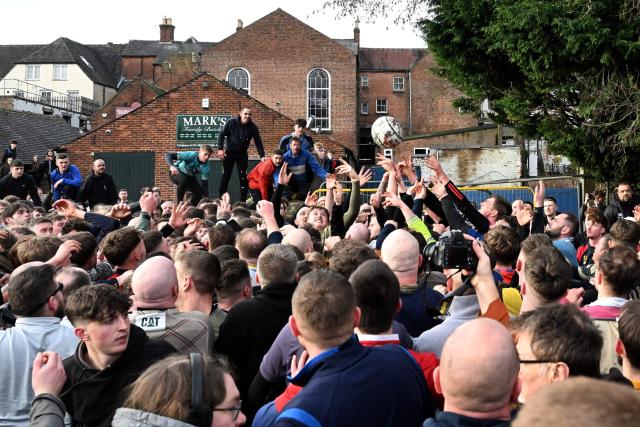 Competitors from the opposing teams, the Up'ards and the Down'ards, fight for the ball during the annual Royal Shrovetide Football match in Ashbourne, northern England on February 17, 2026. The mass-participation ball game involves two teams, whose players are defined by which side of a small brook that bisects the town they were born, aiming to score a goal, which are some three miles (4.8 km) apart. The game, which has very few rules and believed to have been played annually since 1667, is played over two eight hour periods on Shrove Tuesday and Ash Wednesday. (Photo by Paul ELLIS / AFP)