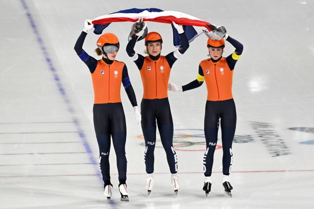 (From L) Netherlands' Antoinette Rijpma-de Jong, Netherlands' Joy Beune and Netherlands' Marijke Groenewoud celebrate with a Netherlands flag after winning silver in the speed skating women's team pursuit final during the Milano Cortina 2026 Winter Olympic Games at Milano Speed Skating Stadium in Milan on February 17, 2026. (Photo by Daniel MUNOZ / AFP)