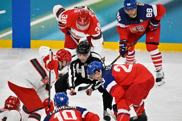 USA's referee Jake Davis holds the puck as players get ready for the men's qualification play-off ice hockey match between Czech Republic and Denmark at the Milano Santagiulia Ice Hockey Arena during the Milano Cortina 2026 Winter Olympic Games in Milan, on February 17, 2026. (Photo by Alexander NEMENOV / AFP)