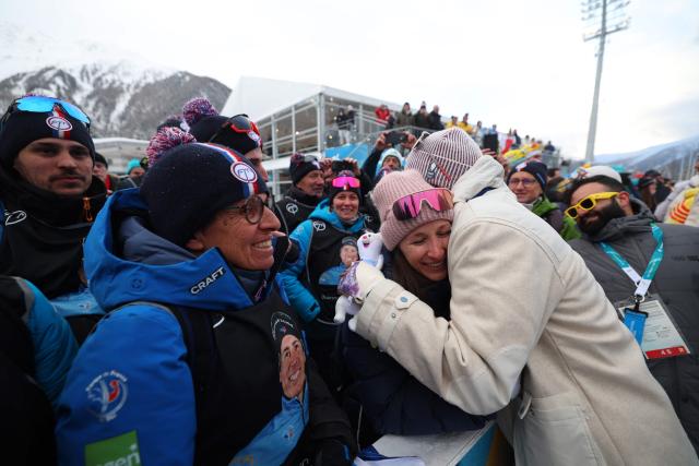 Gold medallist France's Quentin Fillon Maillet celebrates with his partner after competing in the men's biathlon 4 x 7,5km relay event during the Milano Cortina 2026 Winter Olympic Games at the Anterselva Biathlon Arena (Sudtirol Arena) in Anterselva (Val Pusteria) on February 17, 2026. (Photo by FRANCK FIFE / AFP)