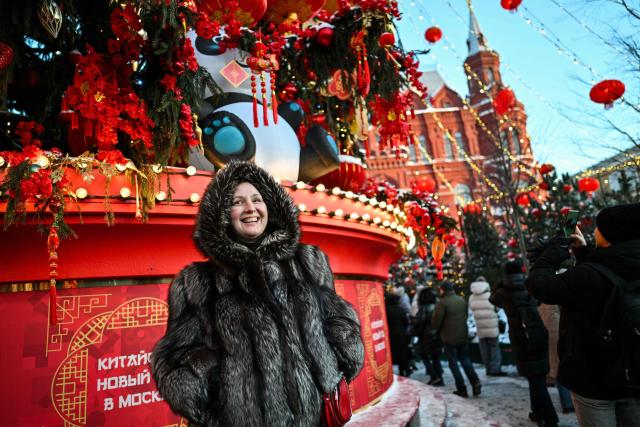 A woman poses for pictures during the Lunar New Year of the Horse celebrations at Moscow's Manezhnaya Square on February 17, 2026. (Photo by Hector RETAMAL / AFP)