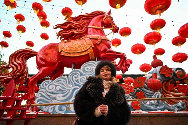 A woman poses for pictures during the Lunar New Year of the Horse celebrations at Moscow's Manezhnaya Square on February 17, 2026. (Photo by Hector RETAMAL / AFP)