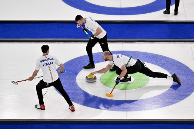 Italy's Mattia Giovanella, Italy's Sebastiano Arman and Italy's Amos Mosaner compete in the curling men's round robin between USA and Italy during the Milano Cortina 2026 Winter Olympic Games at the Cortina Curling Olympic Stadium in Cortina d’Ampezzo on February 17, 2026. (Photo by Tiziana FABI / AFP)