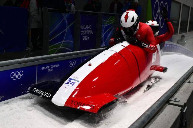 Trinidad and Tobago's Axel Brown and Trinidad and Tobago's De Aundre John compete in the bobsleigh men's 2-man heat 3 at Cortina Sliding Centre during the Milano Cortina 2026 Winter Olympic Games in Cortina d'Ampezzo on February 17, 2026. (Photo by Stefano RELLANDINI / AFP)