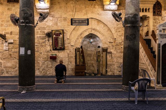A Palestinian man prays in a mosque in the old city of Nablus in the occupied West Bank on February 17, 2026, a day before the start of the Muslim holy month of Ramadan. For Muslims across the world, the beginning of the ninth month in the Muslim lunar calendar which marks the start of Ramadan, is a time for spiritual reflection, prayers, fasting and family reunions around the table after breaking the fast. (Photo by JOHN WESSELS / AFP)