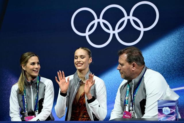 Switzerland's Kimmy Repond (C) reacts in the kiss and cry area after competing in the figure skating women's single skating short program during the Milano Cortina 2026 Winter Olympic Games at Milano Ice Skating Arena in Milan on February 17, 2026. (Photo by WANG Zhao / AFP)