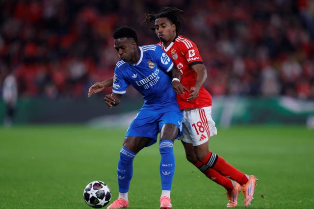 Real Madrid's Brazilian forward #07 Vinicius Junior fights for the ball with SL Benfica's Luxembourgish midfielder #18 Leandro Barreiroduring the UEFA Champions League knockout round play-off first leg football match between SL Benfica and Real Madrid CF at Estadio da Luz in Lisbon on February 17, 2026. (Photo by FILIPE AMORIM / AFP)