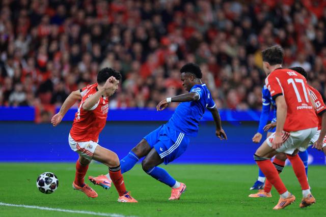 Real Madrid's Brazilian forward #07 Vinicius Junior attempts to score in spite of SL Benfica's Portuguese defender #44 Tomas Araujo during the UEFA Champions League knockout round play-off first leg football match between SL Benfica and Real Madrid CF at Estadio da Luz in Lisbon on February 17, 2026. (Photo by PATRICIA DE MELO MOREIRA / AFP)