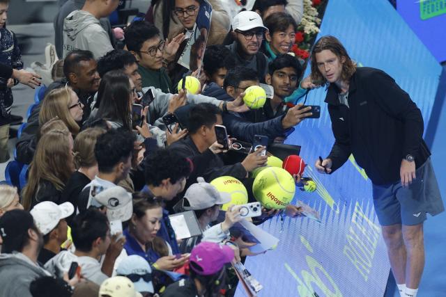 Russia's Andrey Rublev poses for a picture with fans after winning against Netherlands’ Jesper De Jong during their men’s singles match at the Qatar Open tennis tournament in Doha on February 17, 2026. (Photo by Karim JAAFAR / AFP)