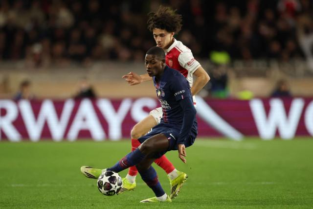 Monaco's French midfielder #11 Maghnes Akliouche and Paris Saint-Germain's Portuguese defender #25 Nuno Mendes (front) fight for the ball during the UEFA Champions League knockout round play-off first leg football match between AS Monaco and Paris Saint-Germain at the Stade Louis II in the Principality of Monaco on February 17, 2026. (Photo by Valery HACHE / AFP)