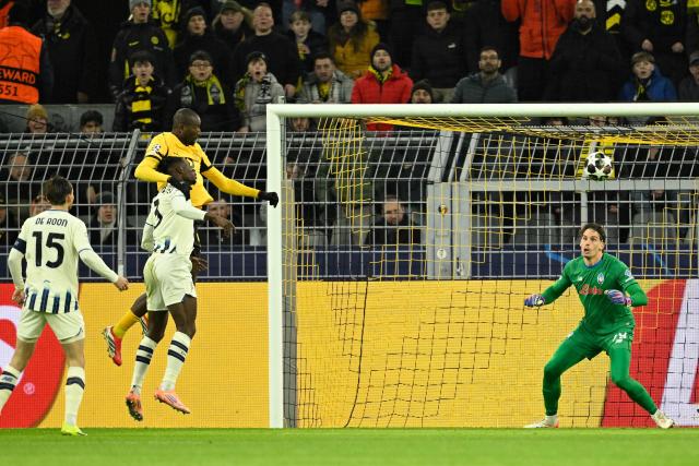 Dortmund's Guinean forward #09 Serhou Guirassy (L) scores his team's first goal during the UEFA Champions League knockout round play-off first Leg football match between BVB Borussia Dortmund and Atalanta Bergamo in Dortmund, western Germany, on February 17, 2026. (Photo by INA FASSBENDER / AFP)