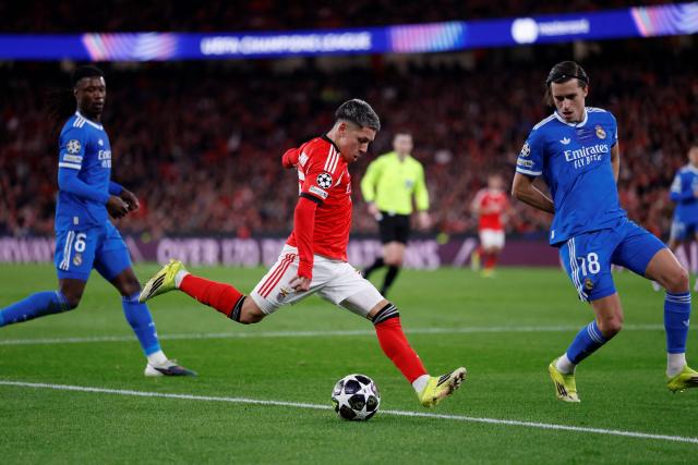 SL Benfica's Argentine forward #25 Gianluca Prestianni fights for the ball with Real Madrid's Spanish defender #18 Alvaro Carreras during the UEFA Champions League knockout round play-off first leg football match between SL Benfica and Real Madrid CF at Estadio da Luz in Lisbon on February 17, 2026. (Photo by FILIPE AMORIM / AFP)