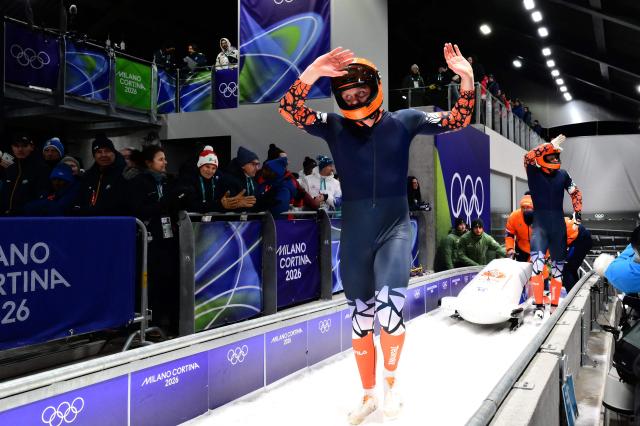 Netherlands' Dave Wesselink and Netherlands' Jelen Franjic react after competing in the bobsleigh men's 2-man heat 4 at Cortina Sliding Centre during the Milano Cortina 2026 Winter Olympic Games in Cortina d'Ampezzo on February 17, 2026. (Photo by Stefano RELLANDINI / AFP)