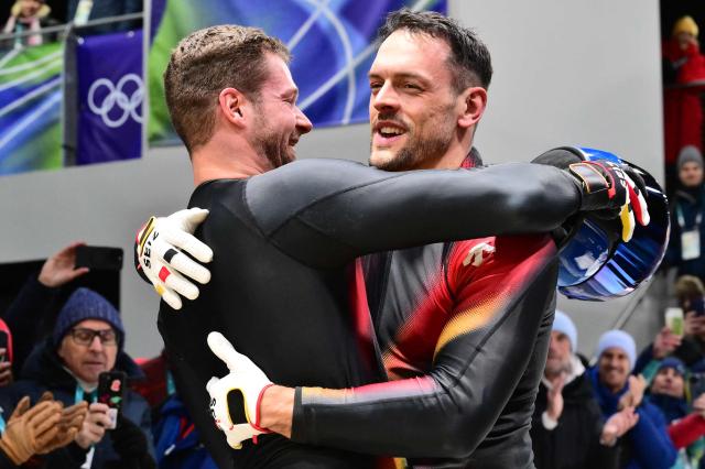 Germany's Johannes Lochner (L) and Germany's Georg Fleischhauer celebrate after winning the bobsleigh men's 2-man heat 4 at Cortina Sliding Centre during the Milano Cortina 2026 Winter Olympic Games in Cortina d'Ampezzo on February 17, 2026. (Photo by Stefano RELLANDINI / AFP)