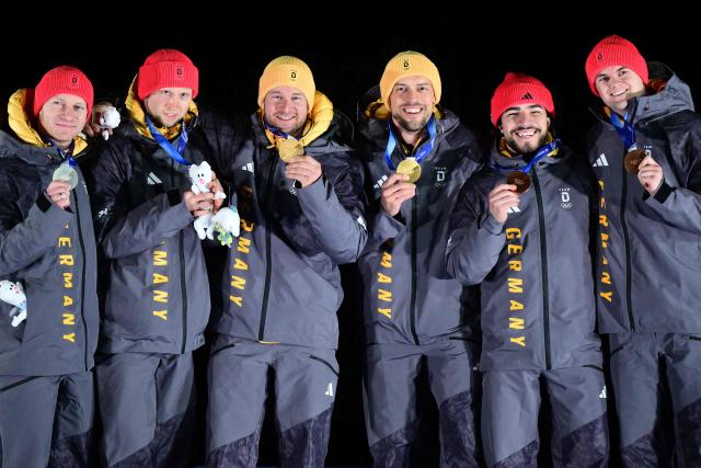 TOPSHOT - (From L) Silver medallists Germany's Francesco Friedrich and Germany's Alexander Schueller, gold medallists Germany's Johannes Lochner and Germany's Georg Fleischhauer and bronze medallists Germany's Adam Ammour and Germany's Alexander Schaller celebrate on the podium after competing in the bobsleigh men's 2-man event at Cortina Sliding Centre during the Milano Cortina 2026 Winter Olympic Games in Cortina d'Ampezzo on February 17, 2026. (Photo by Stefano RELLANDINI / AFP)