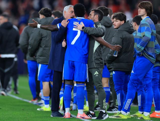 Real Madrid's Brazilian forward #07 Vinicius Junior talks with SL Benfica's Portuguese head coach Jose Mourinho after listening racist insults during the UEFA Champions League knockout round play-off first leg football match between SL Benfica and Real Madrid CF at Estadio da Luz in Lisbon on February 17, 2026. (Photo by PATRICIA DE MELO MOREIRA / AFP)