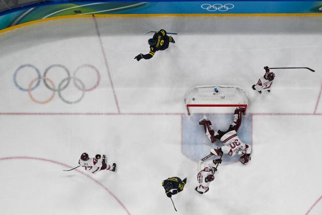 Sweden's #09 Filip Forsberg (top) celebrates after scoring their 3-0 goal during the men's qualification play-off ice hockey match between Sweden and Latvia at the Milano Santagiulia Ice Hockey Arena during the Milano Cortina 2026 Winter Olympic Games in Milan, on February 17, 2026. (Photo by Alexander NEMENOV / AFP)