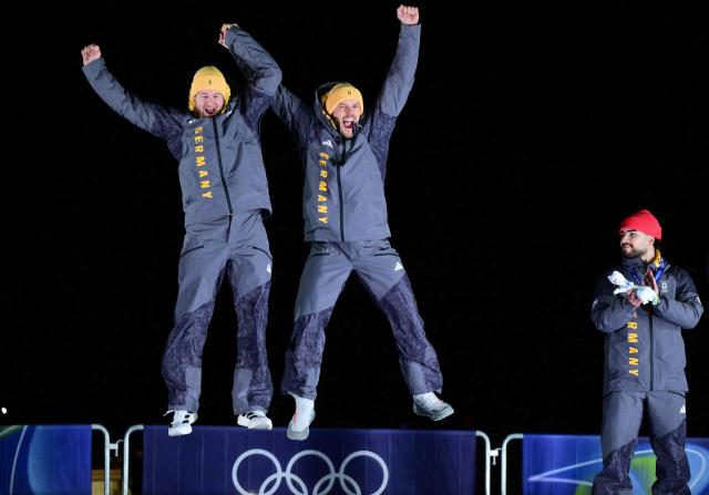 Gold medallists Germany's Johannes Lochner and Germany's Georg Fleischhauer and bronze medallists Germany's Adam Ammour celebrate on the podium after competing in the bobsleigh men's 2-man event at Cortina Sliding Centre during the Milano Cortina 2026 Winter Olympic Games in Cortina d'Ampezzo on February 17, 2026. (Photo by Stefano RELLANDINI / AFP)