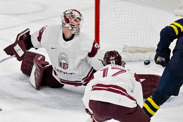 Latvia's #30 Elvis Merzlikins (L) concedes the third goal by Sweden during the men's qualification play-off ice hockey match between Sweden and Latvia at the Milano Santagiulia Ice Hockey Arena during the Milano Cortina 2026 Winter Olympic Games in Milan, on February 17, 2026. (Photo by Alexander NEMENOV / AFP)