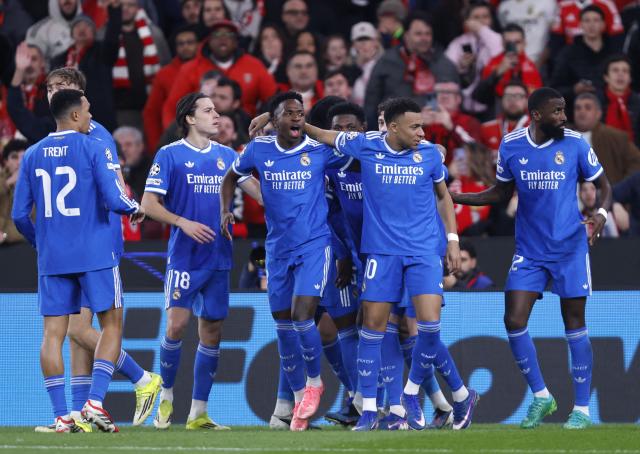 Real Madrid's Brazilian forward #07 Vinicius Junior (C,L) celebrates with teammates scoring his team's first goal during the UEFA Champions League knockout round play-off first leg football match between SL Benfica and Real Madrid CF at Estadio da Luz in Lisbon on February 17, 2026. (Photo by FILIPE AMORIM / AFP)