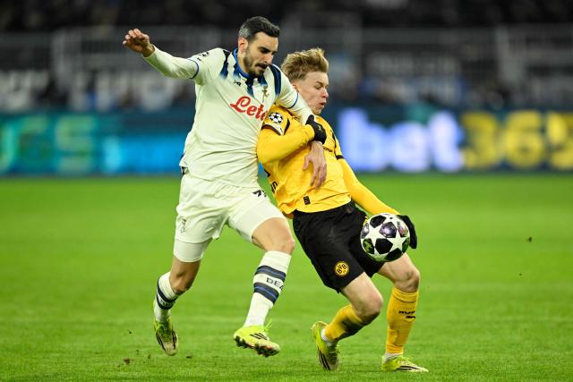 Atalanta's Italian defender #77 Davide Zappacosta and Dortmund's Swedish defender #24 Daniel Svensson vie for the ball during the UEFA Champions League knockout round play-off first Leg football match between BVB Borussia Dortmund and Atalanta Bergamo in Dortmund, western Germany, on February 17, 2026. (Photo by INA FASSBENDER / AFP)