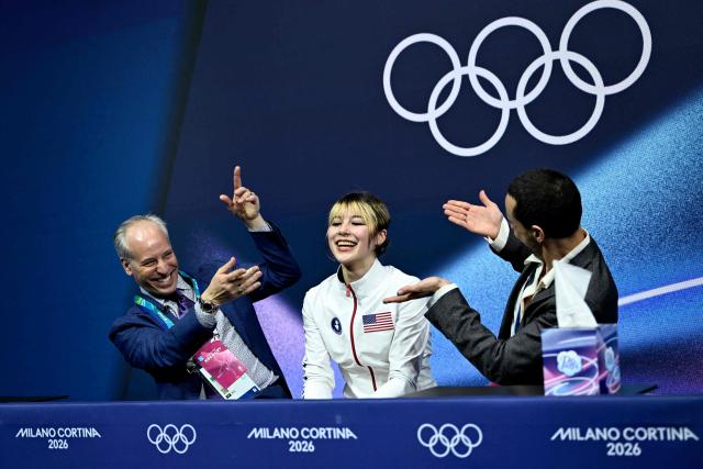 USA's Alysa Liu (C) reacts in the kiss and cry area after competing in the figure skating women's single skating short program during the Milano Cortina 2026 Winter Olympic Games at Milano Ice Skating Arena in Milan on February 17, 2026. (Photo by WANG Zhao / AFP)