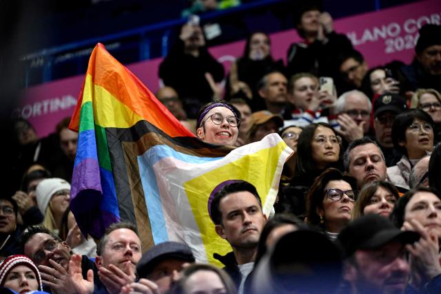 A fan holds an LGBTQ+ "Progress Pride" flag during the figure skating women's single skating short program during the Milano Cortina 2026 Winter Olympic Games at Milano Ice Skating Arena in Milan on February 17, 2026. (Photo by WANG Zhao / AFP)