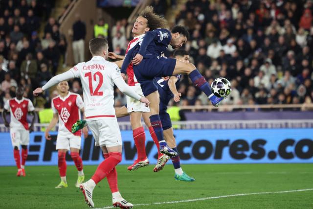 Paris Saint-Germain's French midfielder #33 Warren Zaire-Emery (R) jumps for the ball with Monaco's Belgian defender #25 Wout Faes (back) during the UEFA Champions League knockout round play-off first leg football match between AS Monaco and Paris Saint-Germain at the Stade Louis II in the Principality of Monaco on February 17, 2026. (Photo by Valery HACHE / AFP)