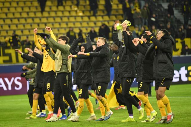 Dortmund's players celebrate with fans after winning 2:0 the UEFA Champions League knockout round play-off first Leg football match between BVB Borussia Dortmund and Atalanta Bergamo in Dortmund, western Germany, on February 17, 2026. (Photo by INA FASSBENDER / AFP)